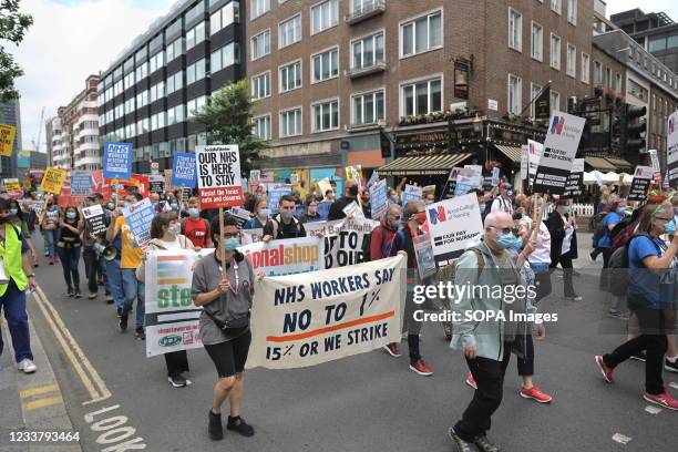 Protesters hold banners and placards while marching in central London during the demonstration. On the weekend of the 73rd anniversary of the NHS in...