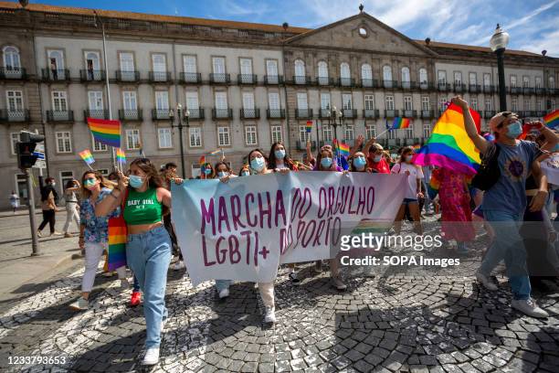 Participants hold a banner and LGBT flags during the parade. Hundreds of people marched on the streets of Porto in Portugal to celebrate the 16th...