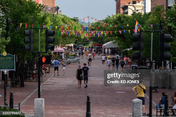 People walk along Church street in Burlington, Vermont on June 28, 2021. - Vermont -- known for Bernie Sanders, the first Ben and Jerry's and golden...