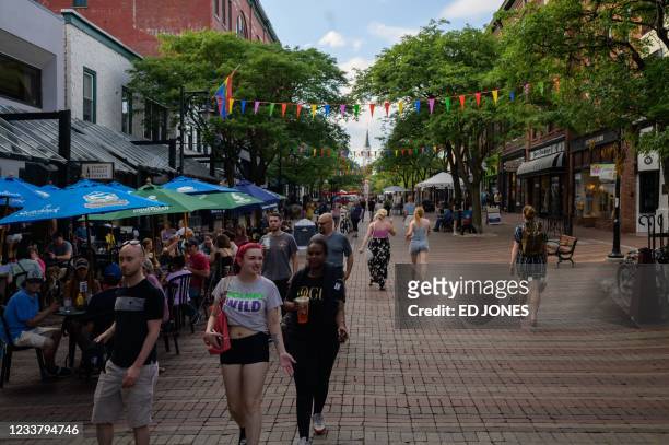 People walk along Church street in Burlington, Vermont on June 28, 2021. - Vermont -- known for Bernie Sanders, the first Ben and Jerry's and golden...