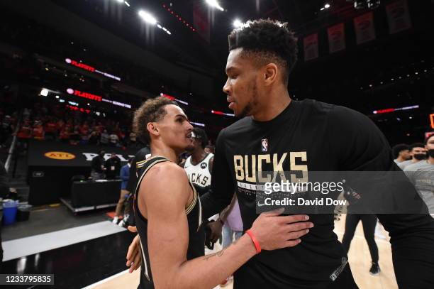Giannis Antetokounmpo of the Milwaukee Bucks hugs Trae Young of the Atlanta Hawks after the game during Game 6 of the Eastern Conference Finals of...