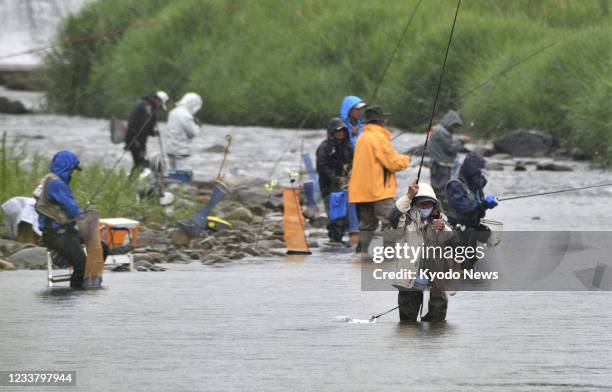 Photo taken on July 4 shows anglers fishing "ayu" sweetfish at a river in Naraha, a Fukushima Prefecture town affected by the March 2011 nuclear...