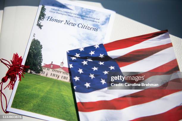 Program and an American flag fan sit on an empty chair before the start of a naturalization ceremony at George Washington's Mount Vernon in Mount...
