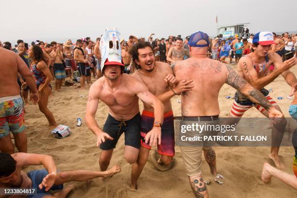 Participants collide with one another in a mosh pit during a punk rock Neckbreaker Band performance following the 47th annual Hermosa Beach Ironman...