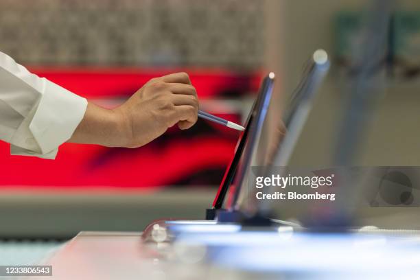 An employee inspects a Samsung Electronics Co. Galaxy S21 Ultra 5G smartphone at the company's Digital Plaza store in Seoul, South Korea, on...