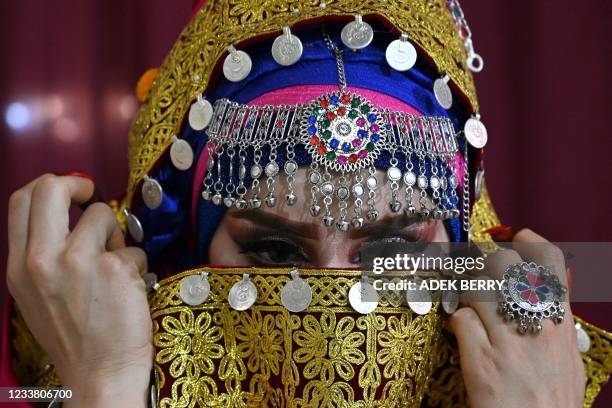 In this photo taken on June 10 a Pashtun bride wearing a traditional costume for her marriage is pictured inside a beauty parlour in Kabul. - The...