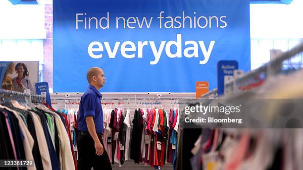 Ross Stores Inc. Sales associate walks past clothing displayed for sale at a location in San Francisco, California, U.S., on Wednesday, Aug. 31,...