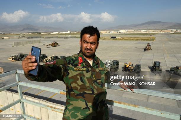 An Afghan National Army soldier takes a selfie with his mobile phone inside the Bagram US air base after all US and NATO troops left, some 70 Kms...