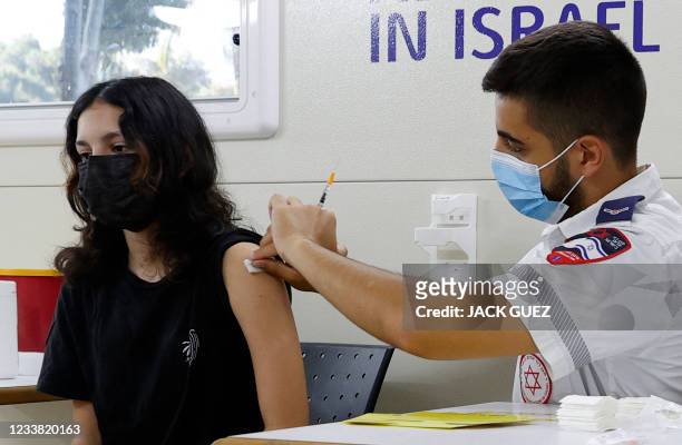 An Israeli girl receives a dose of the Pfizer/BioNTech Covid-19 vaccine from the Magen David Adom during a campaign by the Tel Aviv-Yafo Municipality...