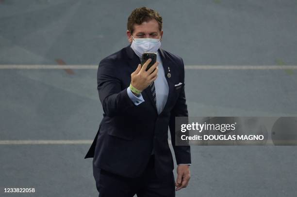 Conmebol's president Paraguayan Alejandro Dominguez checks his mobile phone while waiting for the start of the Conmebol 2021 Copa America football...