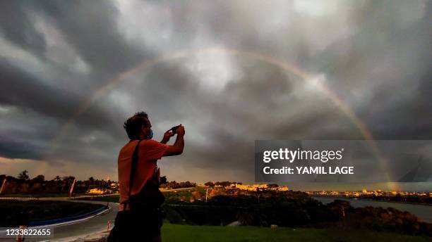 Photographer takes pictures of the tainbow before the passage of Tropical Storm Elsa in Havana, on July 5, 2021.