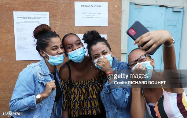 Students make a selfie after they have checked the results of the baccalaureat exam at a high school in Saint-Denis de la Reunion, on the French...