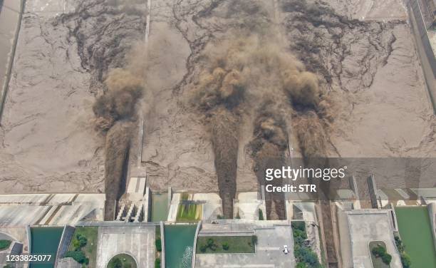 This photo taken on July 5, 2021 shows water being released from the Xiaolangdi Reservoir Dam in Luoyang in China's central Henan province. - China...