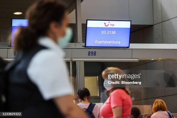 Travelers queue for a flight to Fuerteventura on Spain's Canary Islands, at the TUI AG flight check-in desks at Frankfurt Airport in Frankfurt,...