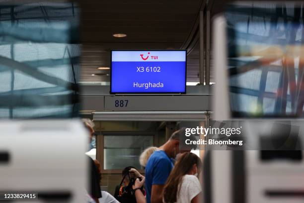 Travelers check-in for a flight to Hurghada, Egypt, at the TUI AG flight desk at Frankfurt Airport in Frankfurt, Germany, on Tuesday, July 6, 2021....