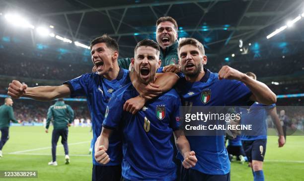 Italy's midfielder Jorginho celebrates with teammates after scoring in a penalty shootout and winning the UEFA EURO 2020 semi-final football match...