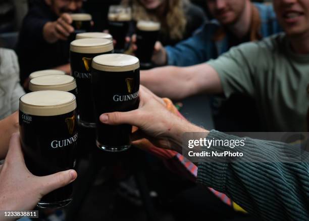 People enjoy drinking Guinness outside a pub in Dublin city center. On Monday, 05 July 2021, in Dublin, Ireland