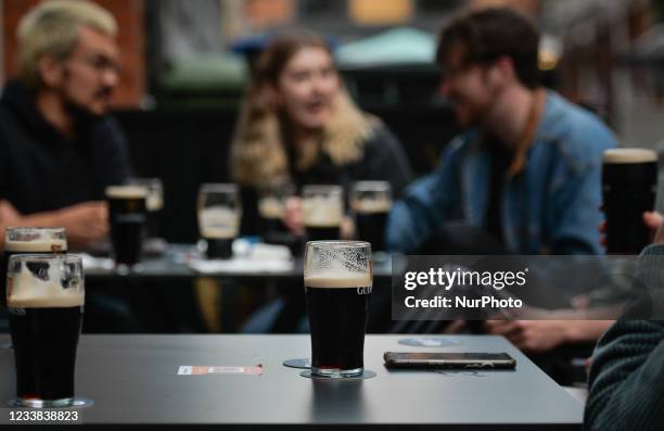 People enjoy drinking Guinness outside a pub in Dublin city center. On Monday, 05 July 2021, in Dublin, Ireland