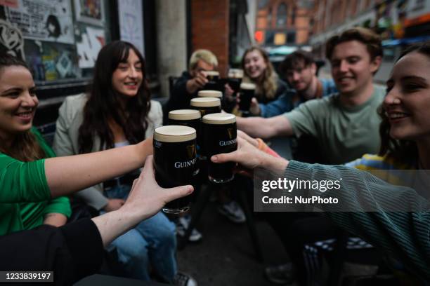 People enjoy drinking Guinness outside a pub in Dublin city center. On Monday, 05 July 2021, in Dublin, Ireland