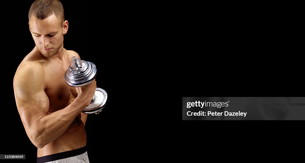Body builder with dumbbell and copy space