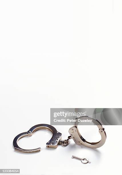 unlocked police handcuffs with copy space - handcuffs photos et images de collection