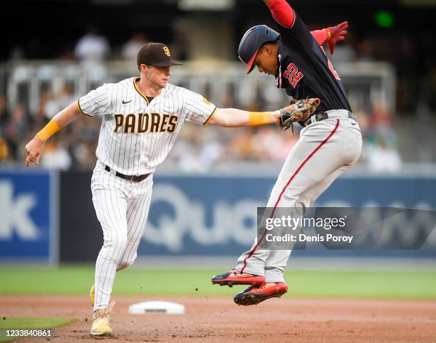 Jake Cronenworth of the San Diego Padres tags out Juan Soto of the Washington Nationals between first and second bases in the first inning at Petco...