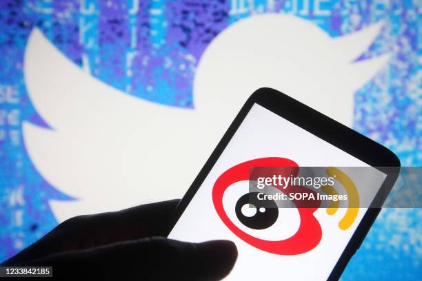 In this photo illustration a Weibo logo of a Chinese social media platform is seen on a smartphone with a Twitter website in the background.