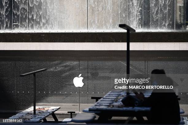Woman is silhouetted near the installation "The Moral of the Story", by French artist Neïl Beloufa, near the Apple Store in Piazza Liberty in Milan,...
