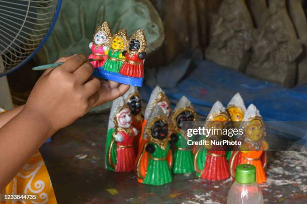 Girl giving final touches to an idol of Jagannath , Balram and Subhadra , at a potters hub , ahead of Rath -Yatra celebration in Kolkata , India , on...