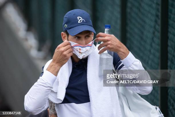 Serbia's Novak Djokovic put on his face covering as he leaves the Aorangi Practice Courts on the ninth day of the 2021 Wimbledon Championships at The...