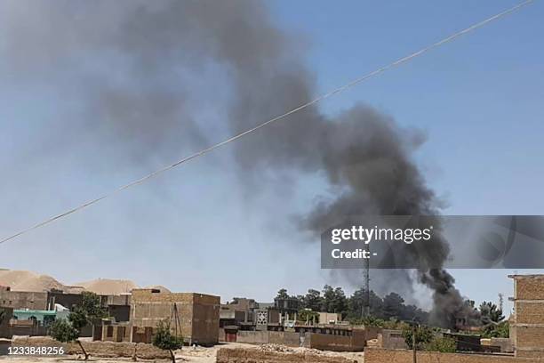 Smoke plume rises from houses amid ongoing fight between Afghan security forces and Taliban fighters in the western city of Qala-i- Naw, the capital...