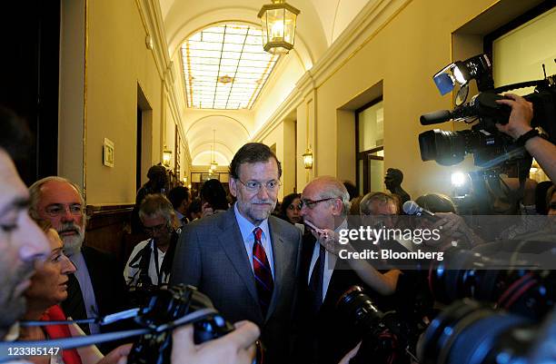 Mariano Rajoy, leader of Spain's opposition People's Party, is surrounded by media as he leaves the parliament following a vote on changing...