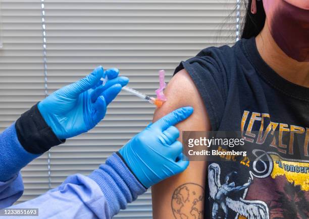 Healthcare worker administers a dose of the Pfizer-BioNTech Covid-19 vaccine to a resident at the Jordan Valley Community Health Center in...