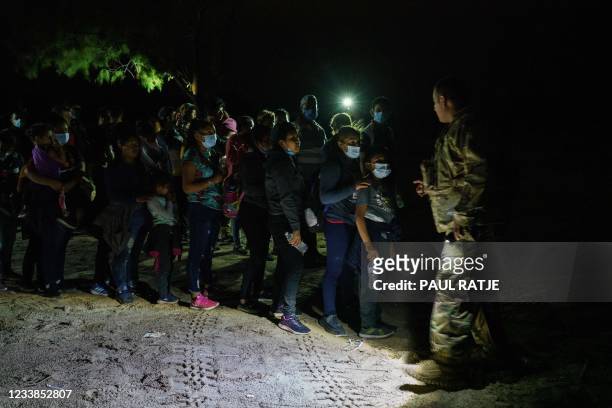 National Guardsman directs migrants into a line who just crossed the Rio Grande into the United States in Roma, Texas on July 6, 2021. - Republican...