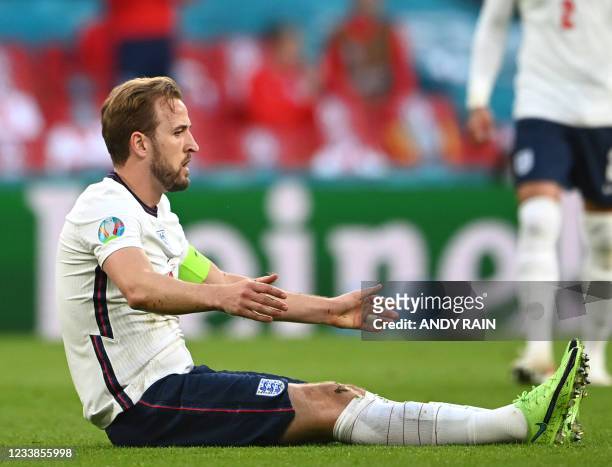 England's forward Harry Kane sits on the pitch after being fouled during the UEFA EURO 2020 semi-final football match between England and Denmark at...