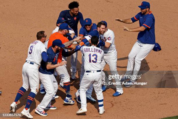 Jeff McNeil of the New York Mets is congratulated by teammates after hitting a walk-off 2-RBI single in the eighth inning against the Milwaukee...