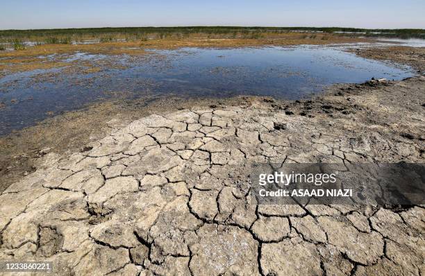 This picture taken on June 20, 2021 shows a view of drying earth in the Chibayesh marshland in Iraq's southern Ahwar area. - As Iraq bakes under a...