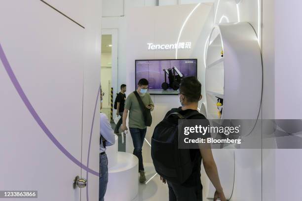 Attendees walk past the Tencent Holding Ltd. Booth at the World Artificial Intelligence Conference in Shanghai, China, on Thursday, July 8, 2021. The...