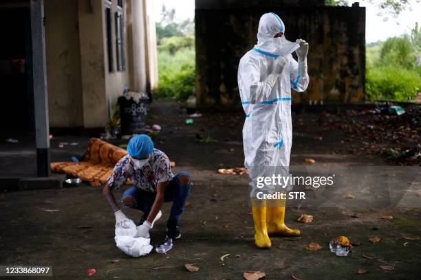 Volunteers take off personal protective equipment after cremating the bodies of people who died from the Covid-19 coronavirus in Taungoo, Bago region...
