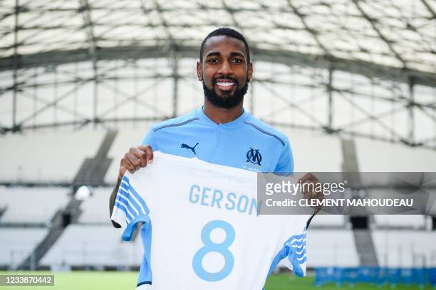 Olympique de Marseille's newly recruited Brazilian midfielder Gerson Santos da Silva poses for pictures holding his jersey during his official...