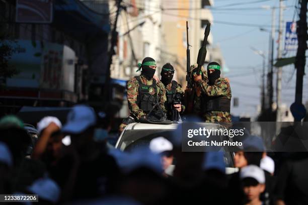 Fighters of Izz ad-Din al-Qassam brigade, the military wing of Hamas, patrol as Palestinians youths take part during a military summer camp in Gaza...