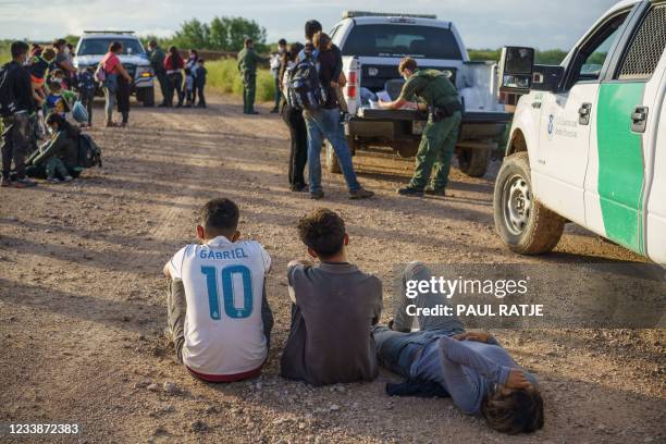 Migrants wait to be processed by the United States Border Patrol after crossing the US-Mexico border into the United States in Penitas, Texas on July...