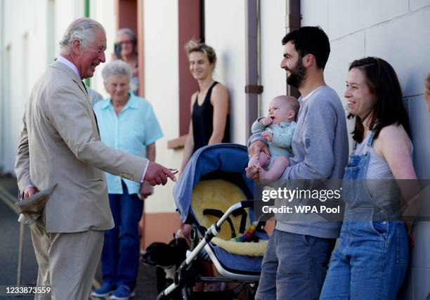 Prince Charles, Prince of Wales speaks to James Roden and Bethan Walker about their 4-month old baby, Idris Roden, as he walks around town on July 8,...