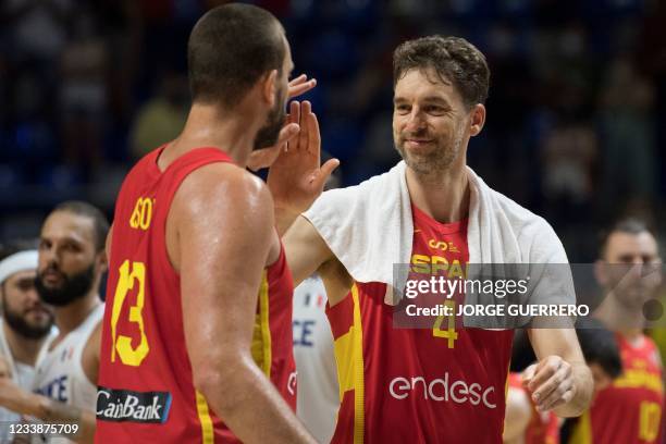 Spain's forward Marc Gasol celebrates with his brother, forward Pau Gasol after winning 86-77 the international friendly basketball match between...