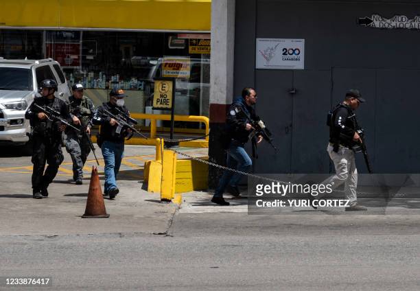 Members of the Bolivarian National Intelligence Service arrive to the area of clashes between police and alleged members of a criminal gang in the...