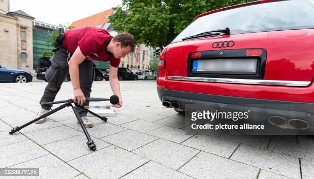 July 2021, Lower Saxony, Hanover: Hendrik Vorreiter of the Hanover police prepares the volume measurement with a sound level meter on a car. Police...