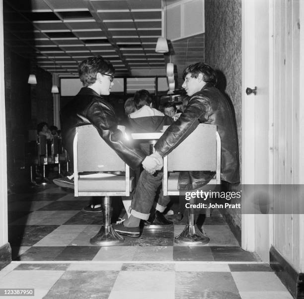 Young Mods Ray and Jenny holding hands in a cafe in London, 1964.