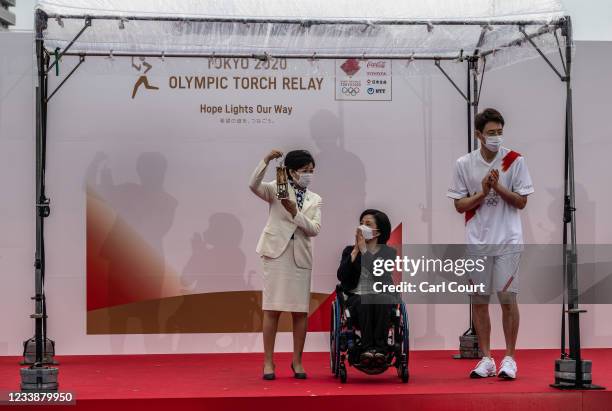Tokyo Governor Yuriko Koike holds the Olympic torch in a lantern during an unveiling ceremony for the Tokyo leg of Olympic torch relay with Aki...