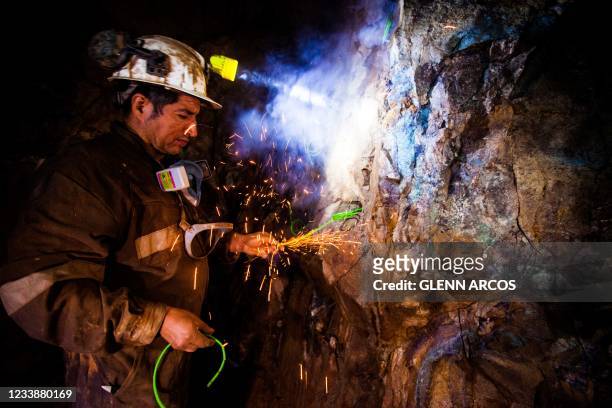 Chilean miner Juan Bugueno places explosives inside the Kiara copper mine, 136 km south of Antofagasta, Chile, after work, on June 22, 2021. - The...