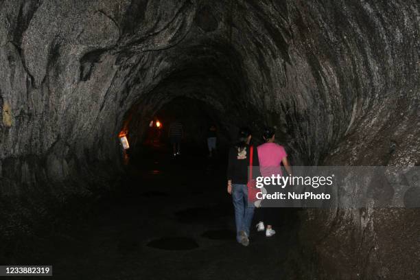 Tourists explore the Nahuku lava tube at Volcanoes National Park on Hawaii's Big Island, USA, on July 09, 2007.